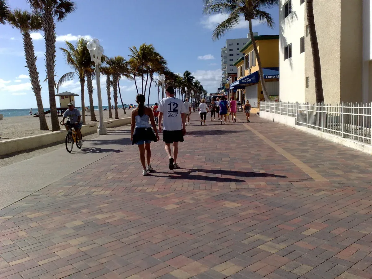 Walkers and a cyclist on the Hollywood Beach Broadwalk, a free day trip north of Miami before a Bahamas cruise from Miami